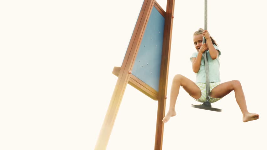 Happy smiling little girl move on zip line in playground or kindergarten yard. Zipline for children in adventure park. Ziplining activity in sunny summer day. Child having fun outdoors