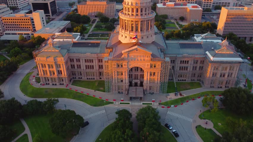 Downtown Austin, Texas State Capital Building, Aerial Drone Shot Flying over Goddess of Liberty Statue on Top with Views of The University of Texas at Austin Campus Skyline at Sunset in 4K.