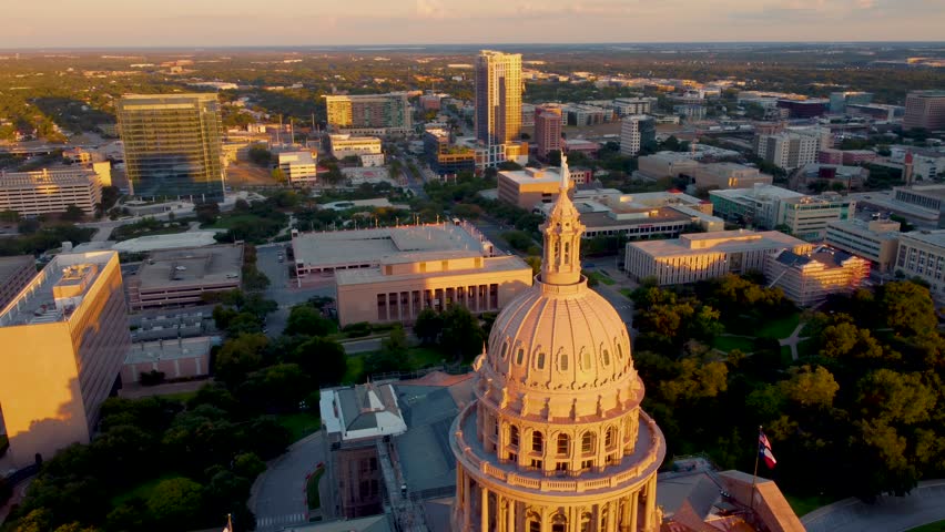 Downtown Austin, Texas State Capital Building, Aerial Drone Shot Circling Dome with Goddess of Liberty Statue on Top with Views of The University of Texas at Austin Campus, Skyline at Sunset in 4K. Royalty-Free Stock Footage #1109694083