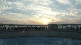 View of crowd of people at the observation deck in sunset time. Urban skyline and shiny glass window. Time lapse shot, dusk to night. Shot at Osaka, Japan. City and nature concept 4K video.