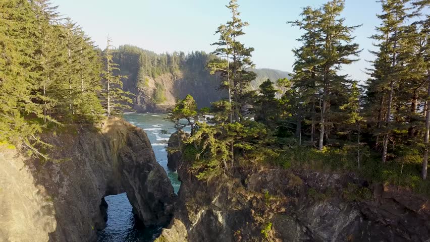 Oregon Coast, Viewpoint of "Natural Bridge" rock formations. 4K Aerial drone looking down from above, waves crashing, forming natural arches in the rocky cliffs.