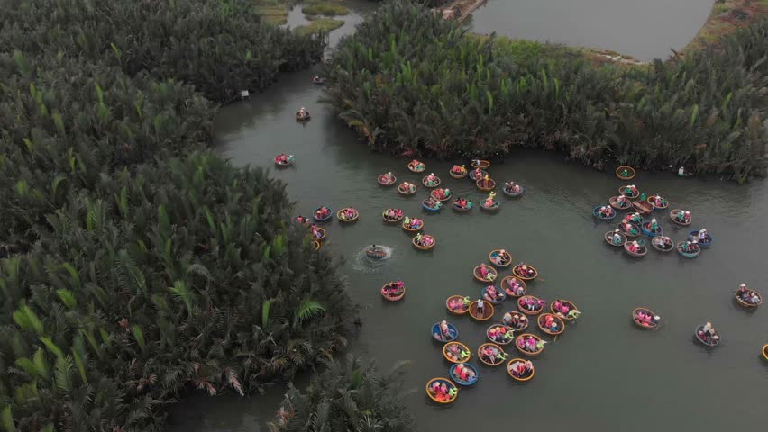 Tourists having an excursion and fun in Thu Bon river coconut boats Vietnam, aerial