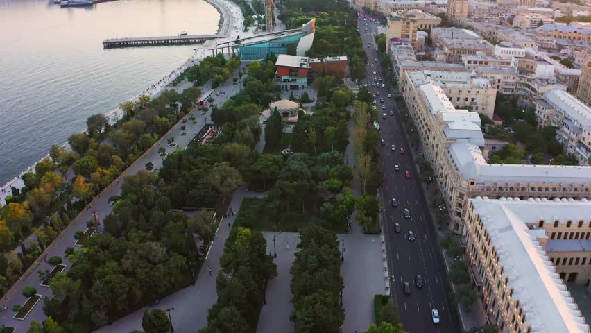 Aerial – Natural parkland along the coastline and streets of Baku old town after sunset, Azerbaijan Royalty-Free Stock Footage #1109713093