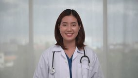 Portrait of happy young Asian female doctor talking to patient via video call, looking at camera make video chat conference call, Medical online
