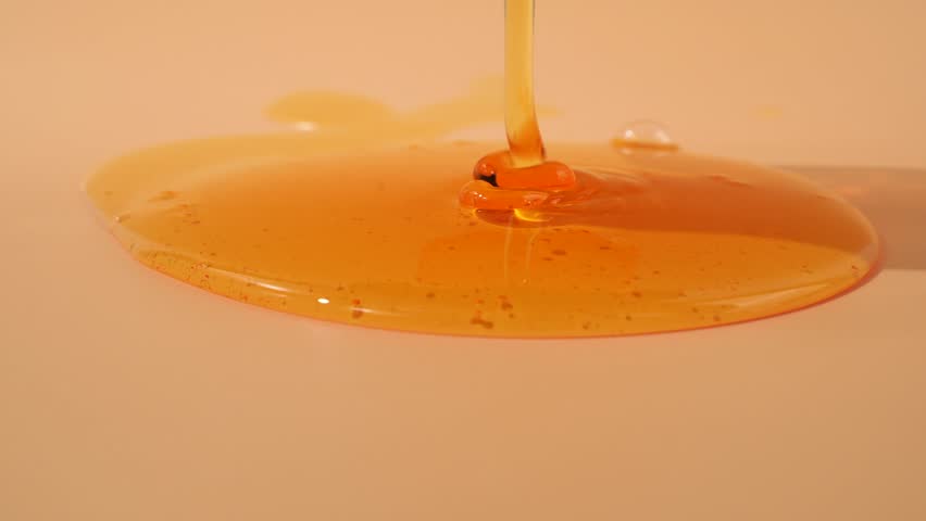 Liquid shower gel flows gracefully across a bright orange background.