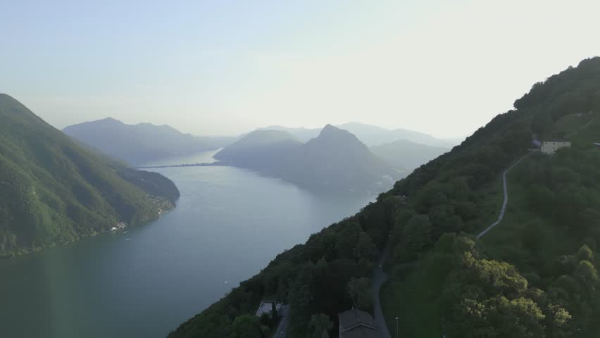 Aerial dolly with stunning view of Lake Lugano, Switzerland and Mount Brè. Incredible landscape of mountains and lake.  Drone shot over Mount Brè, Lugano. 