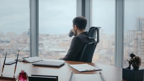 Rich ceo drinking coffee sitting comfortable office chair looking window on cityscape close up. Confident bearded businessman taking break from work. Calm boss relaxing in luxury cabinet with tea cup. - Powered by Shutterstock - Get 15% off with code: PIKWIZARD15