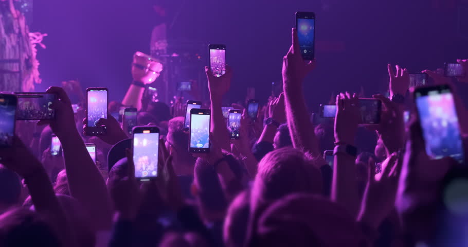 Audience silhouette filming video, photo of music band in stage. Blue phones screens with entertainment event in crowd hands. live festival in night club. Happy people take videos of show performance Royalty-Free Stock Footage #1109740321