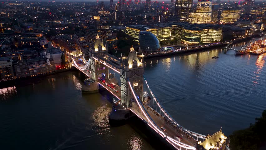 Beautiful aerial close up view of the illuminated Tower Bridge of London during evening time with street traffic