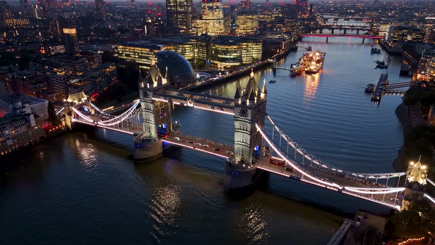 Beautiful aerial close up view of the illuminated Tower Bridge of London during evening time with street traffic