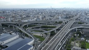 OSAKA, JAPAN - JULY 2023 : Aerial view of high way, road junction and cityscape of downtown. Japanese transportation, street traffic and urban city concept video. Long time lapse shot, dusk to night.