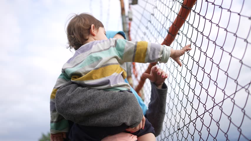 unrecognizable mother and child at the fence , crossing the border refugee problem Royalty-Free Stock Footage #1109752907