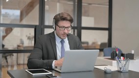 Businessman Chatting Online on Laptop while Sitting in Office
