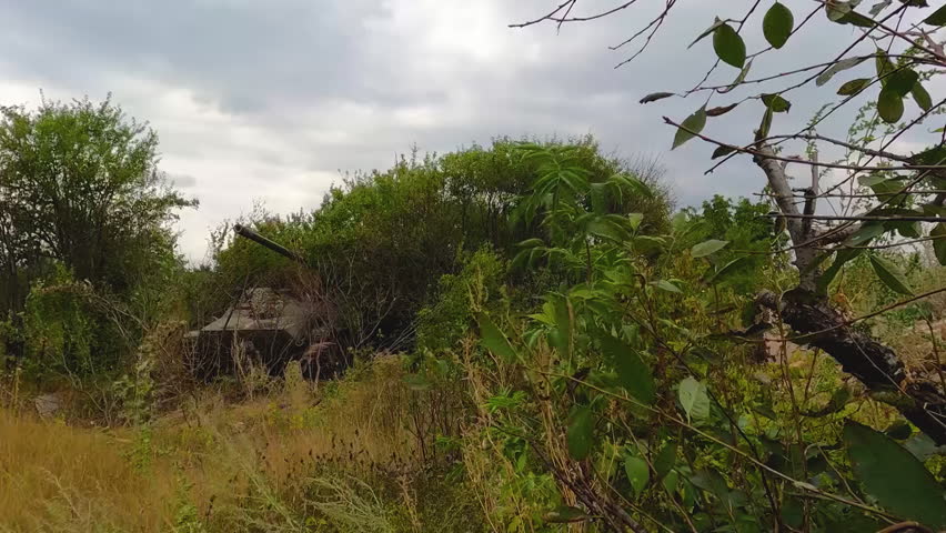 A tank hidden in the bushes shoots. The moment of the shot. Real war, combat operations with heavy armored vehicles Royalty-Free Stock Footage #1109768267