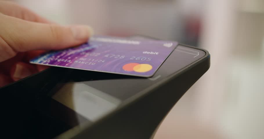 Closeup of customer hand paying with contactless credit card with NFC technology. Payment with pos terminal in store. | Shutterstock HD Video #1109768889