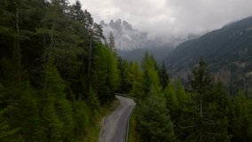 Aerial video at Italian Dolomites shot from a drone in rainy weather. Footage was shot while flying at low altitude above a road revealing the beautiful Dolomites in the background.