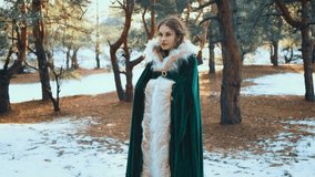 Fantasy woman walks in winter forest. Princess girl. Green long warm medieval clothing fur cape dress old style. Lady witch mystery go to stroll along path sun magic light. Nature green pine tree snow - Powered by Shutterstock - Get 15% off with code: PIKWIZARD15