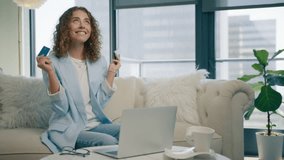 Happy elegant young woman holding credit card using instant mobile payments in modern apartment. Smiling beautiful girl making purchase on smartphone receiving cashback. E-banking app service concept - Powered by Shutterstock - Get 15% off with code: PIKWIZARD15