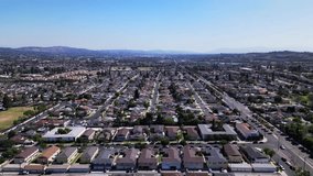 Sliding left view of a neighborhood with lots of nice houses in Southern California with a view of the mountains and no clouds on a summer day. - Powered by Shutterstock - Get 15% off with code: PIKWIZARD15