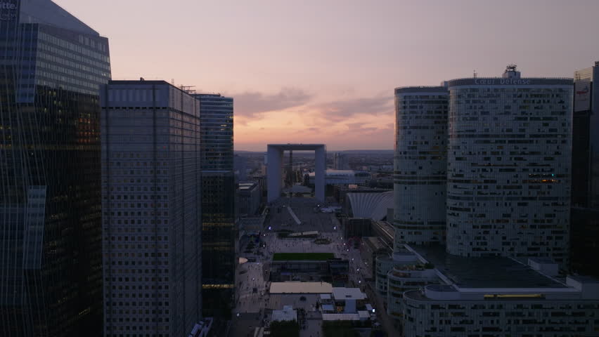 Backwards fly between rows of skyscrapers in futuristic La Defense business district at dusk. Paris, France Royalty-Free Stock Footage #1109775791