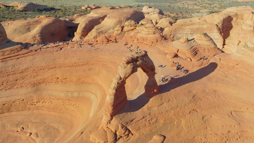 Aerial View Of People Hiking Towards The Sandstone Rock Formations In Arches National Park, Utah, USA. 