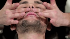 Barber doing facial massage in the men's hair salon