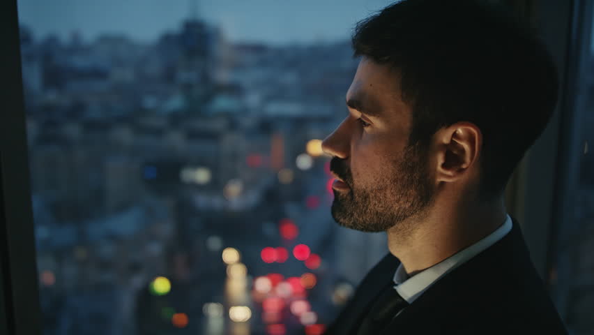 Thoughtful businessman looking evening cityscape standing at office panoramic window alone close up. Portrait of handsome bearded entrepreneur watching night town thinking on career. Work concept. Royalty-Free Stock Footage #1109780503