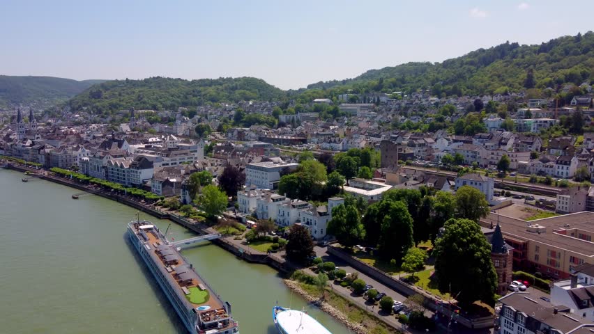 Large Rhine river Passenger cruise ship and Barge hotel docking at port gangway in Boppard city, Germany. Aerial Royalty-Free Stock Footage #1109780965
