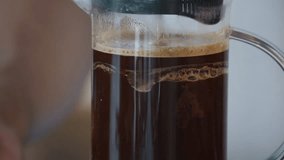 Making French press coffee on the working table at home. Pressing the plunger down - Powered by Shutterstock - Get 15% off with code: PIKWIZARD15