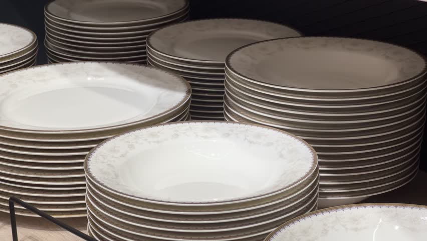 New round plates stacked on the shelf in a crockery store or tableware shop. Close up