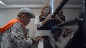 Happy senior couple singing and playing piano at home