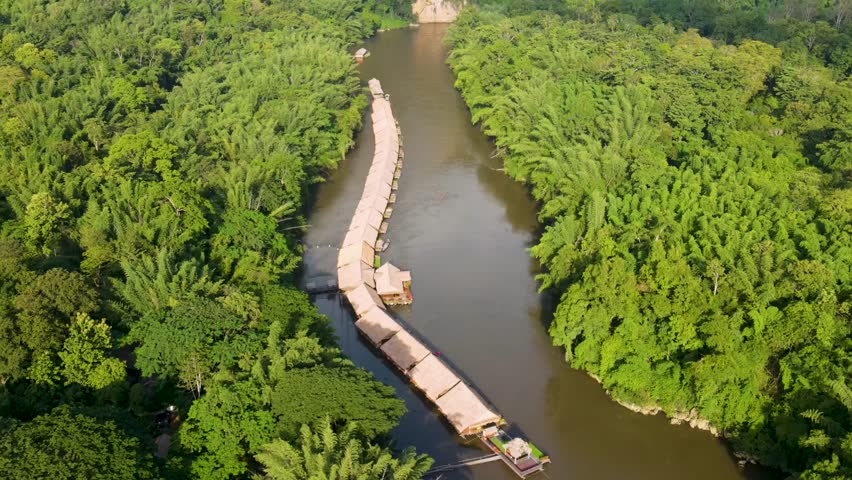 Floating River Kwai hotels surrounded by jungle in Kanchanaburi, at golden hour. Aerial, ascending, dolly backwards Royalty-Free Stock Footage #1109791531