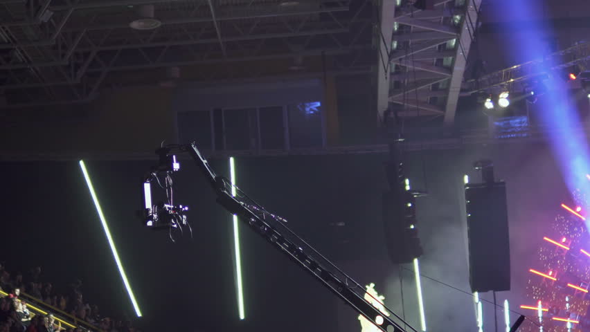 Telescopic crane with a video camera attached. Television is recording events. A camera with a stabilizer moves over the heads of the audience of the concert Royalty-Free Stock Footage #1109794435