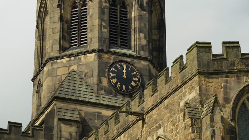Close-up of old Anglo-Saxon church tower with clock, in Peak District countryside, England, in 4K, 60fps