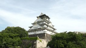 OSAKA, JAPAN -JULY 2023 : View of OSAKA CASTLE (Osaka-jo) at Osaka castle park. One of the most famous historical landmarks in Japan. Time lapse shot in sunny daytime. Travel and tourism concept video