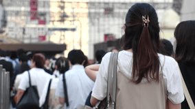View of crowd of people walking in Osaka, Japan. Back shot of unidentified men and women. Shot in sunset time, busy rush hour. Japanese people and urban city lifestyle concept video.