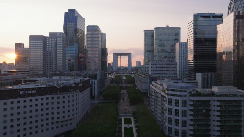 Forwards fly above wide pedestrian boulevard in super modern business district. La Defense at sunset. Paris, France Royalty-Free Stock Footage #1109813541