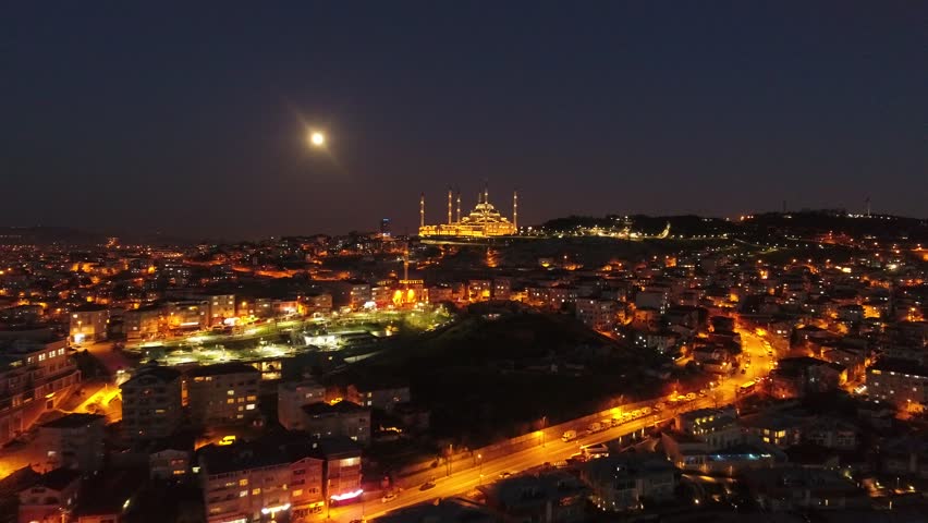 Aerial view of Çamlıca mosque at night with the moon. Aerial view of Istanbul at night
