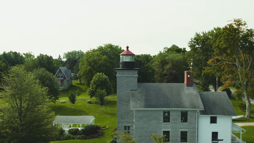 Drone shot of the Big light house museum push in on the large lens at Sodus point New York vacation spot at the tip of land on the banks of Lake Ontario.