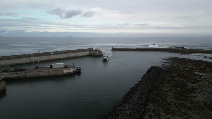 A passenger ship enters the harbor in the village of Seahouses in Northumberland, UK.
