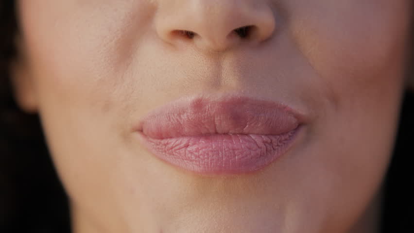 Close-up shot of female lips sending air kiss. Beautiful full pink lips perfect background for cosmetology, plastic surgery, hyaluronic acid injection, lips augmentation procedure, beauty injections Royalty-Free Stock Footage #1109823525