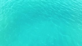 Texture of turquoise sea water, view from a drone. Blue surface of the lagoon. Expansive ocean background with moderate waves looking straight down. Tropical landscape. Tourism.