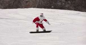 Santa Clause snowboarder riding downhill on ski resort slope. Christmas or New Year celebration, winter sport lifestyle concept - Powered by Shutterstock - Get 15% off with code: PIKWIZARD15