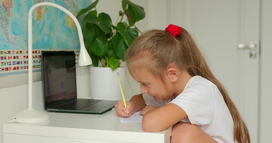 Pretty little girl doing her homework at home on a laptop Royalty-Free Stock Footage #1109840259