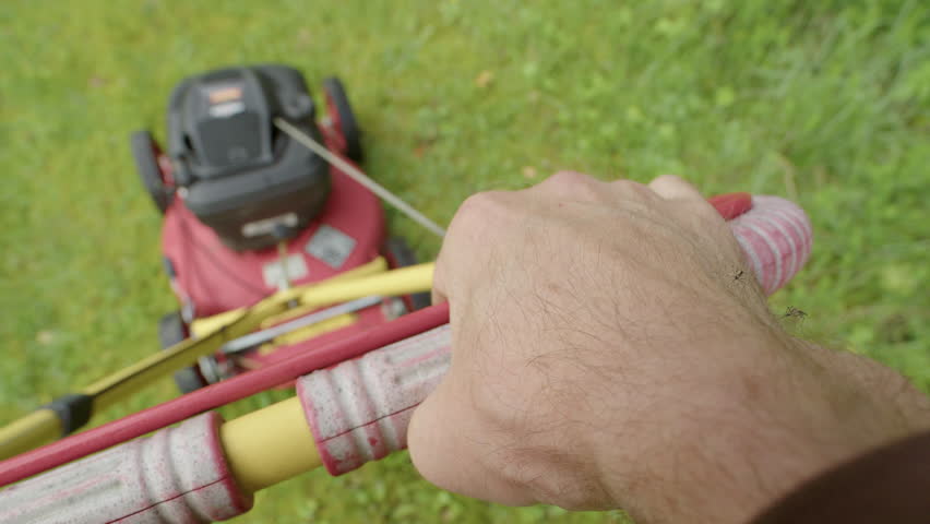 Mosquitoes landing on exposed caucasian hand pushing lawnmower, itchy skin