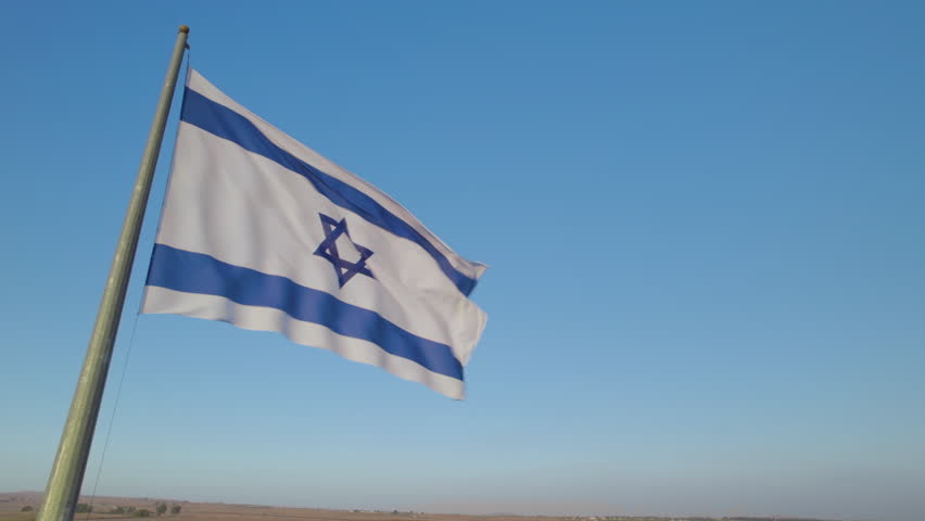 The Israeli flag found against a cloudless blue sky in northern Israel on the Golan Heights Royalty-Free Stock Footage #1109841793