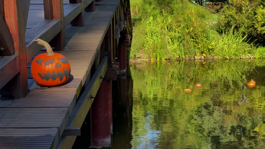 Pumpkins with painted, eerie faces are placed on the bridge, contributing to the park