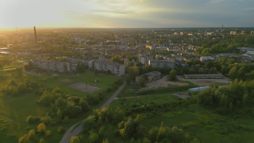 Cinematic aerial view of Daugavpils city in Latvia under sunset sky