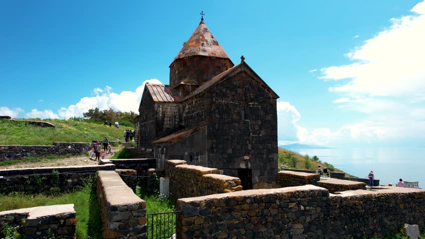 Aerial view church near Sevan in Armenia. Drone fly from Ancient church  Sevanavank monastery․ Tourists near monastery. Famous touristic place.   Royalty-Free Stock Footage #1109851037