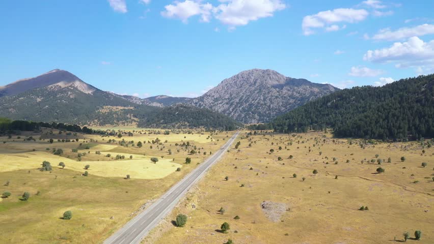 Aerial view of the asphalt road passing through the mountains in Akseki, Antalya. Beautiful mountain road among the steppe. Road trip. Mountain pine forest landscape.Antalya,Turkey.
